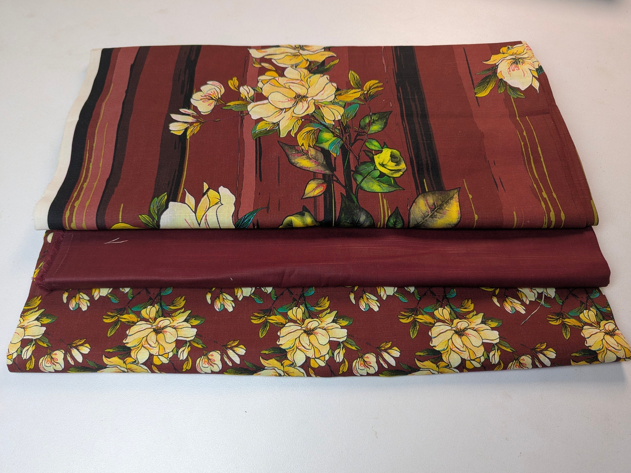 Floral-patterned fabric with yellow flowers on a maroon background
