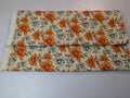 Floral-patterned fabric with orange flowers on a beige background