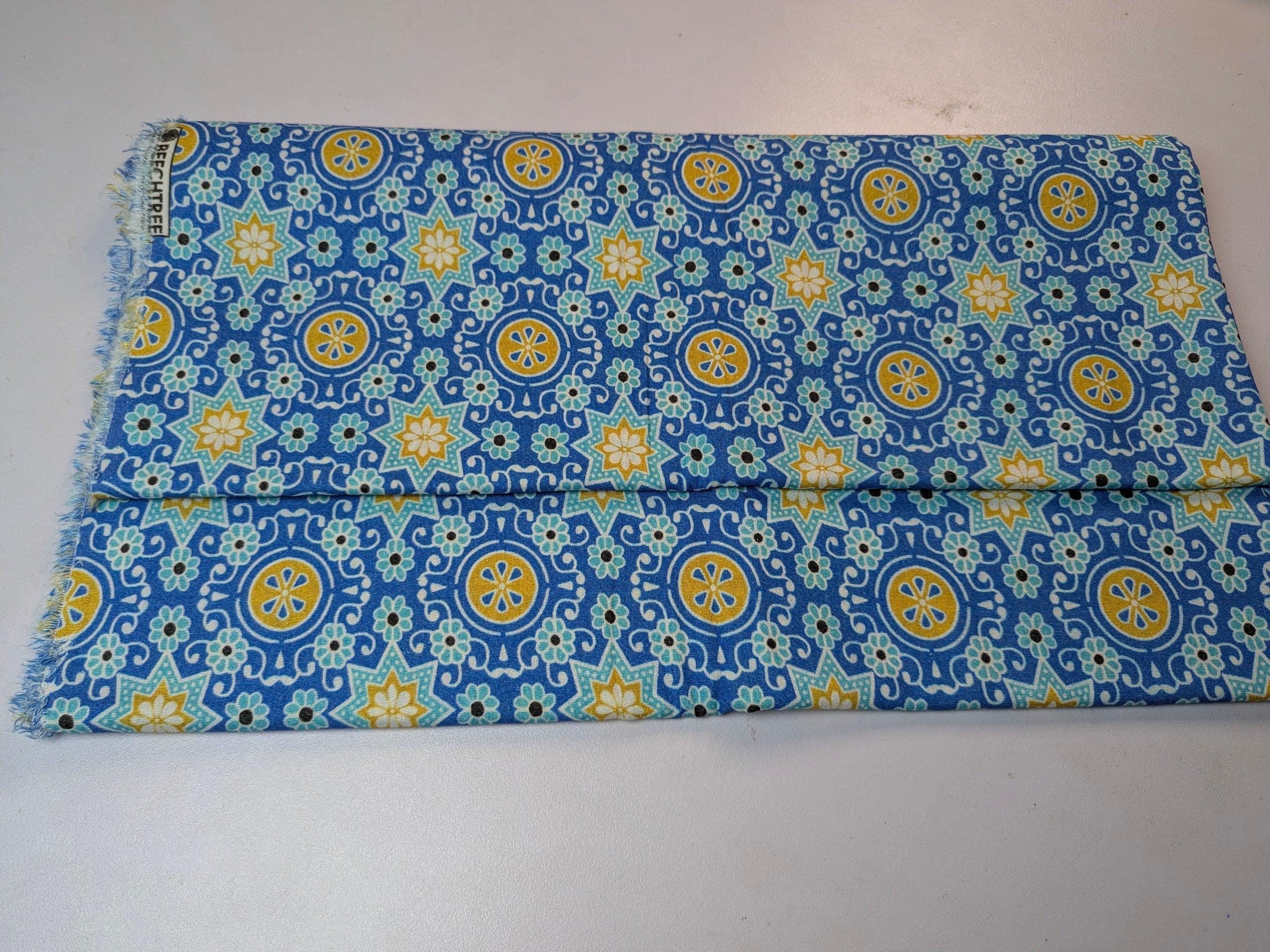 Folded fabric with blue and yellow pattern on a white background