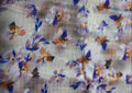 Floral patterned fabric with blue, orange, and purple flowers on a white background